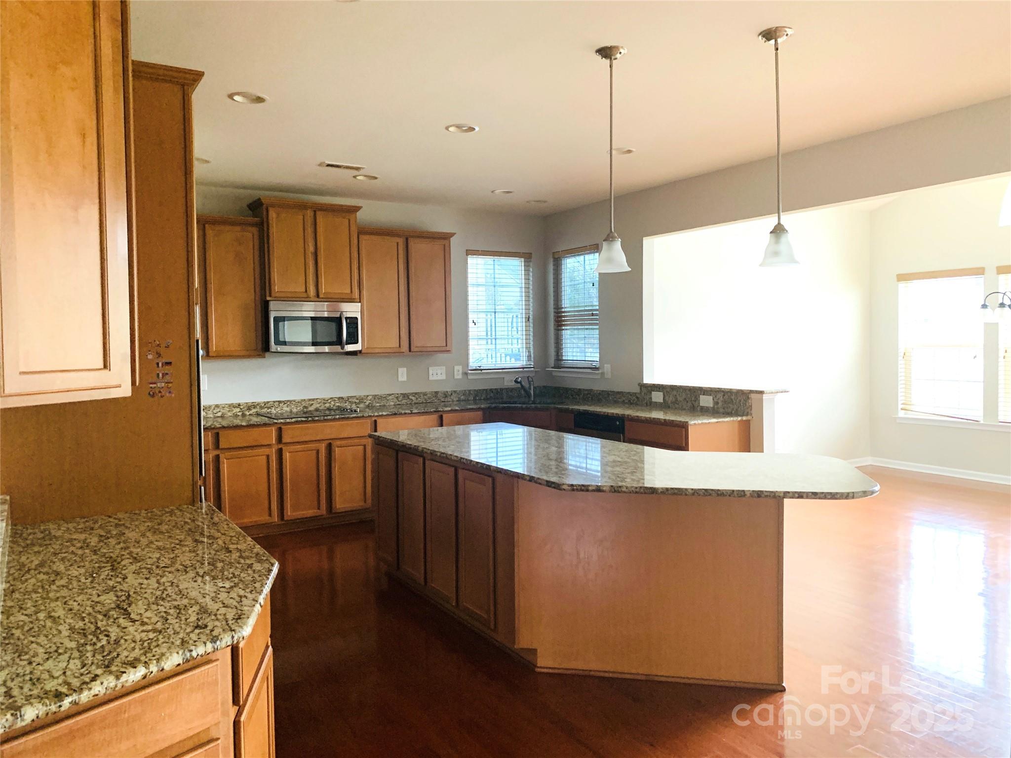 1472 Chandler Avenue Northwest Concord, NC 28027 - Photo 6 of 21 a kitchen with stainless steel appliances granite countertop a sink a stove and a wooden floor