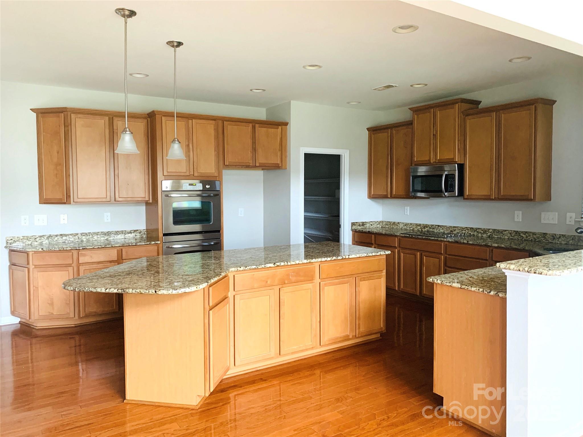 1472 Chandler Avenue Northwest Concord, NC 28027 - Photo 7 of 21 a kitchen with stainless steel appliances granite countertop a sink a stove and a refrigerator