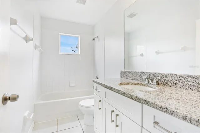 a bathroom with a granite countertop sink a toilet and shower
