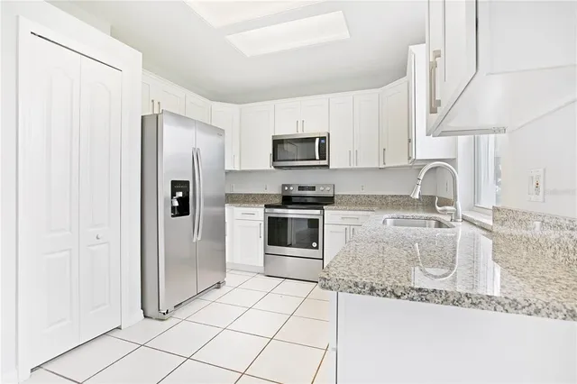 a kitchen with stainless steel appliances granite countertop a refrigerator and a sink