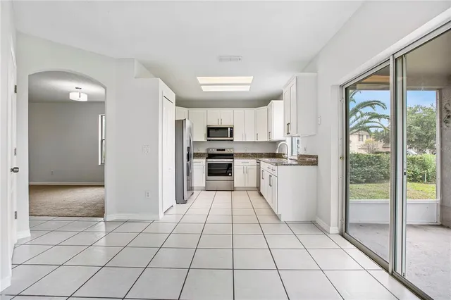 a kitchen with stainless steel appliances granite countertop a refrigerator and a stove top oven