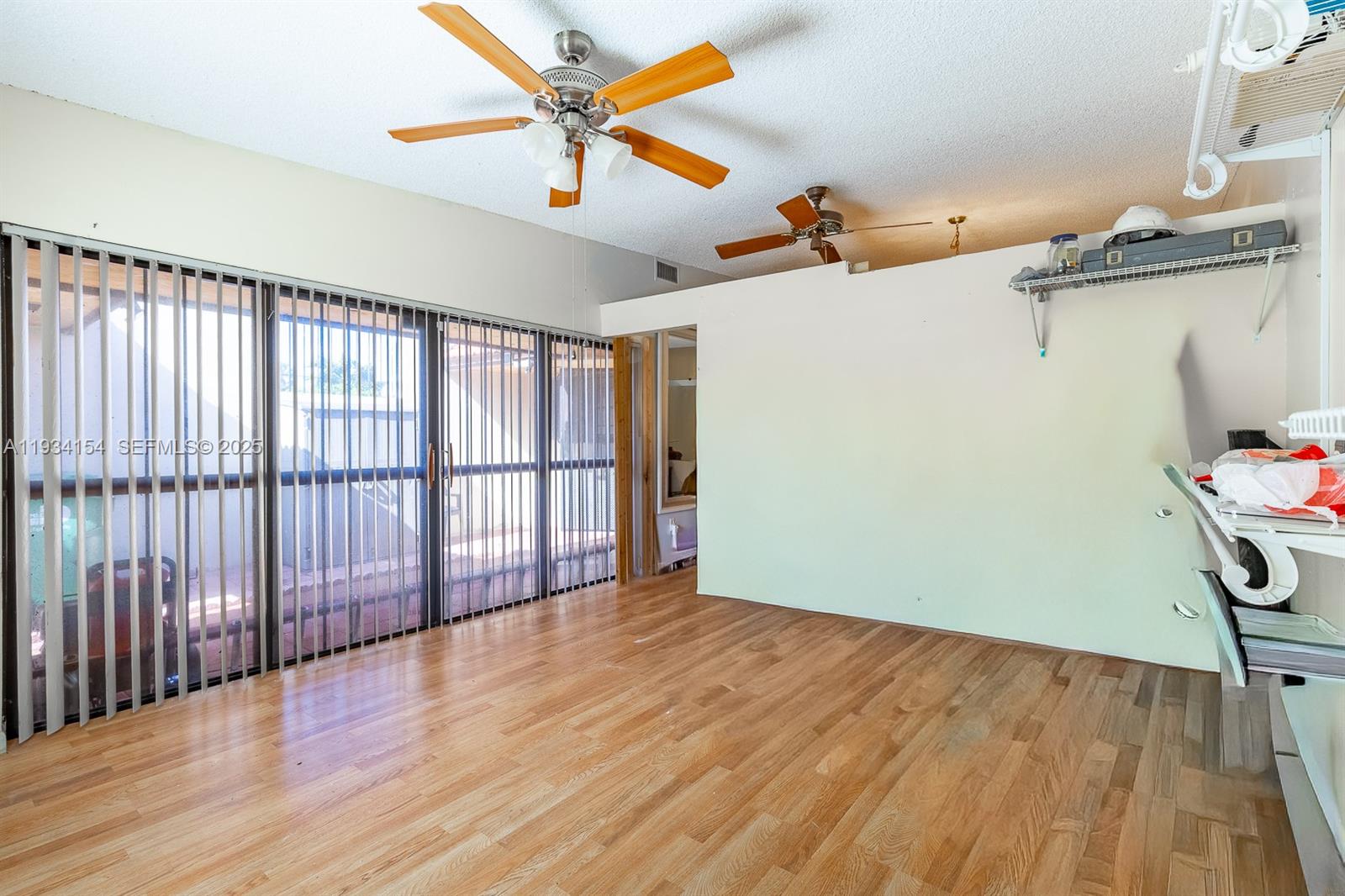 6491 Northwest 190th Terrace Hialeah, FL 33015 - Photo 11 of 28 a view of a room with wooden floor and fan