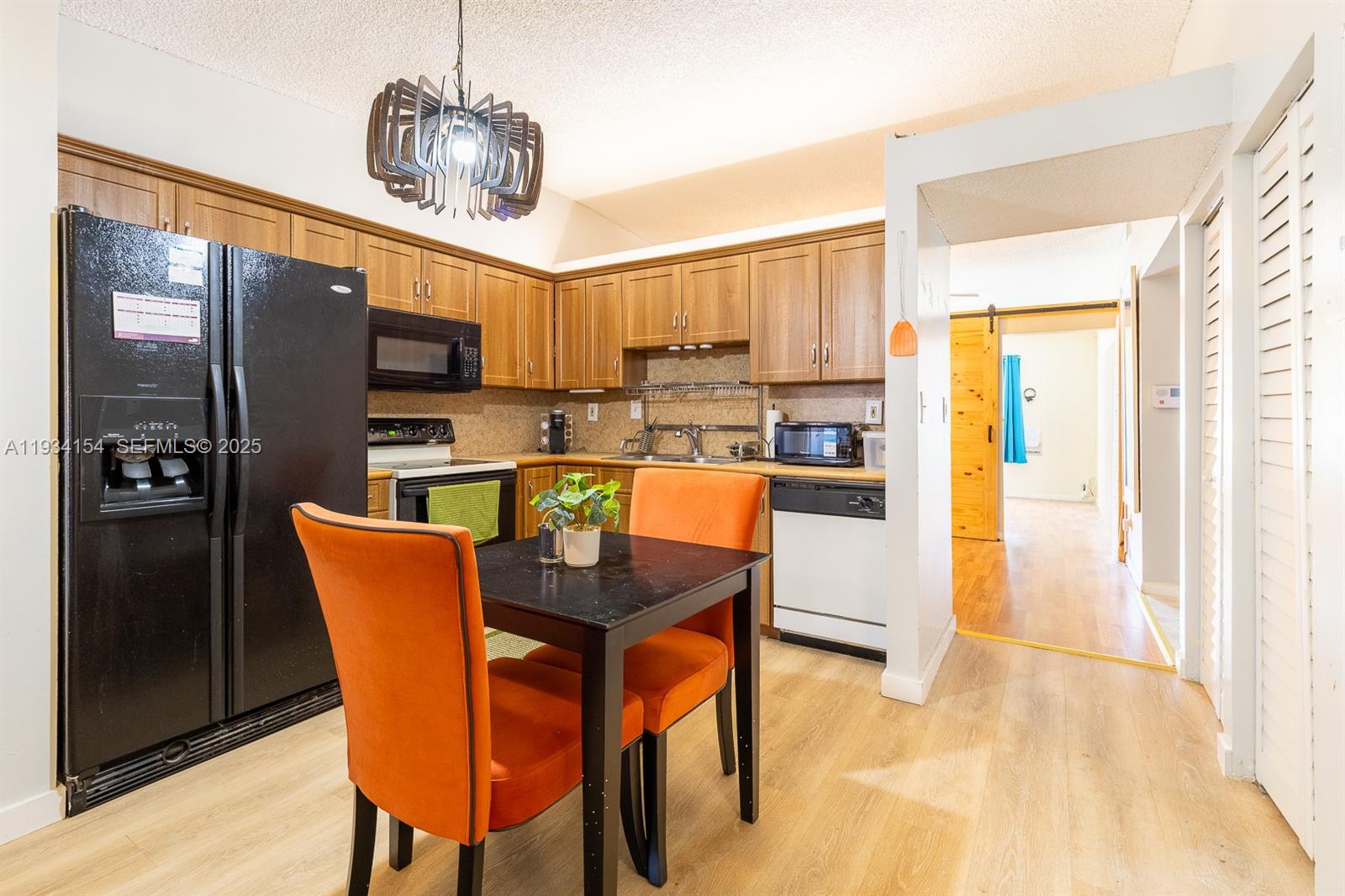 6491 Northwest 190th Terrace Hialeah, FL 33015 - Photo 12 of 28 a dining room filled a chandelier a glass table and chairs