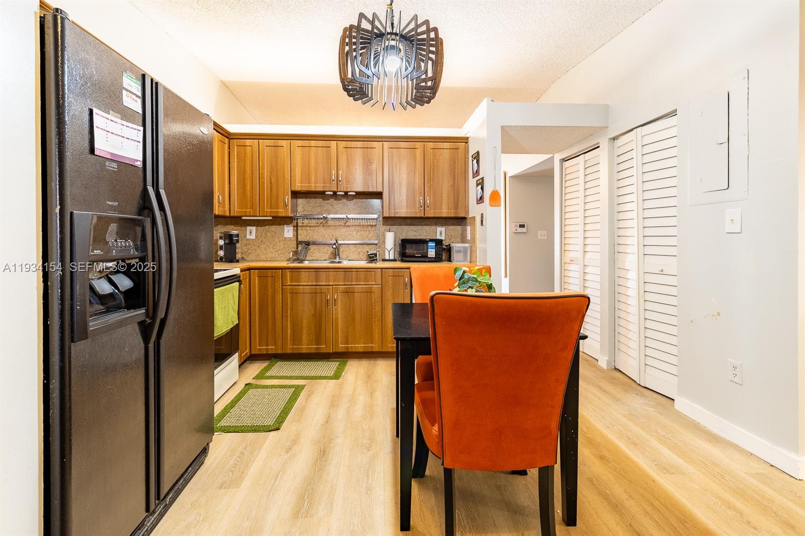 6491 Northwest 190th Terrace Hialeah, FL 33015 - Photo 14 of 28 a kitchen with stainless steel appliances granite countertop a dining table chairs and a refrigerator