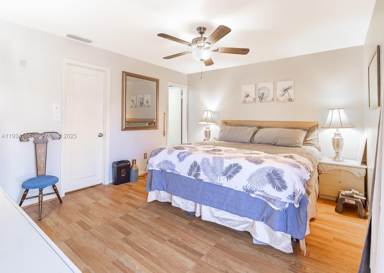 6491 Northwest 190th Terrace Hialeah, FL 33015 - Photo 19 of 28 a bedroom with a large bed and a chandelier