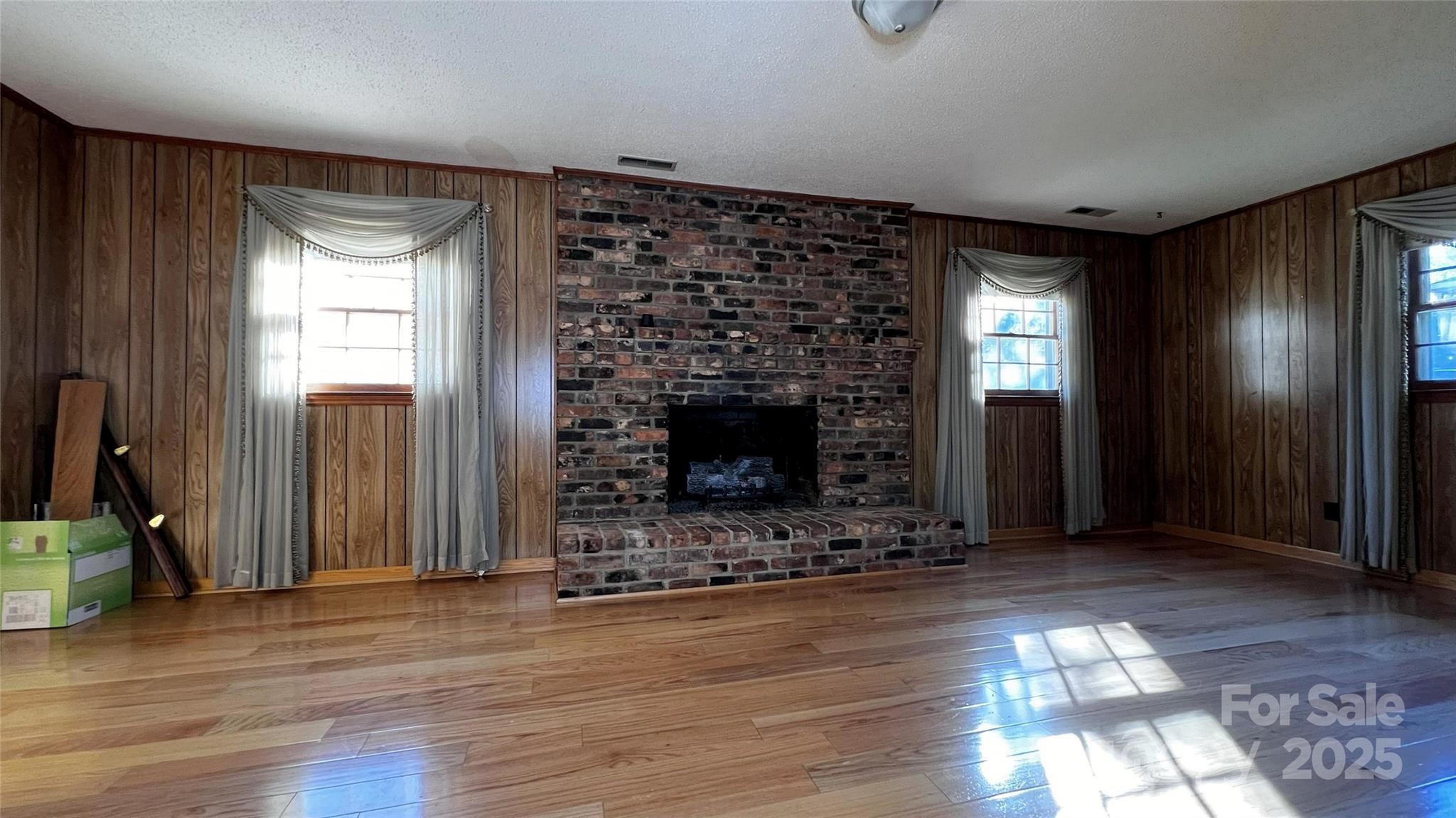 1325 Leolillie Lane Charlotte, NC 28216 - Photo 13 of 35 a view of an empty room with wooden floor fireplace and a window