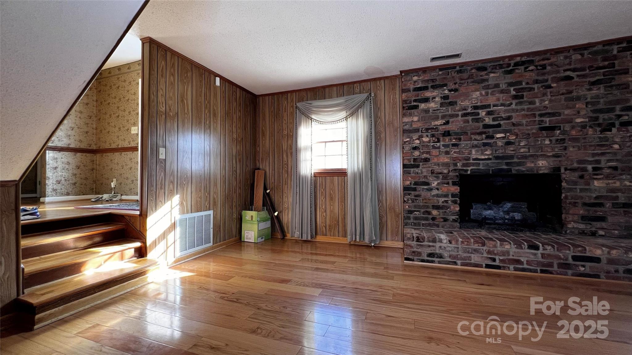 1325 Leolillie Lane Charlotte, NC 28216 - Photo 15 of 35 a view of empty room with wooden floor and fireplace