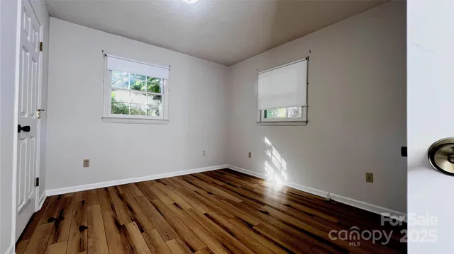 a view of a room with wooden floor and white walls