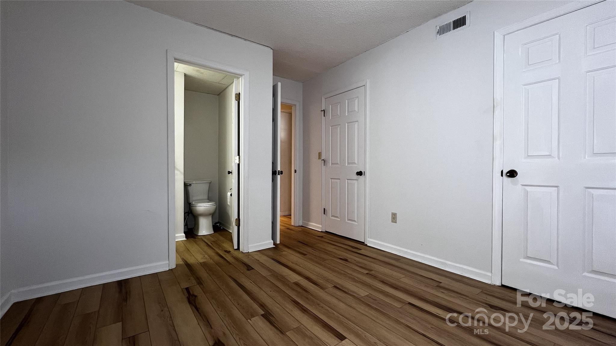 1325 Leolillie Lane Charlotte, NC 28216 - Photo 17 of 35 a view of a room with wooden floor and white walls