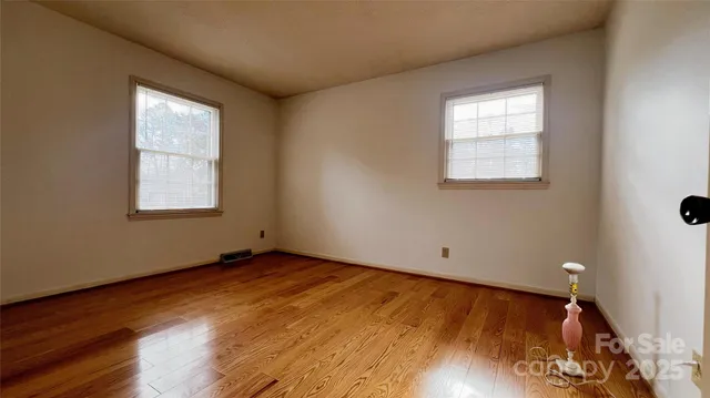 a view of a room with wooden floor and window