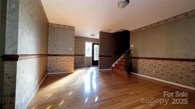a view of a room with wooden floor and windows