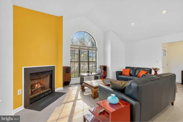 a living room with furniture a fireplace and a large window