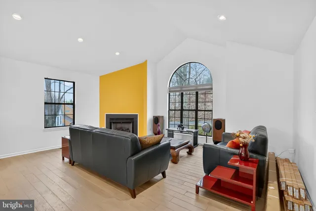 a living room with furniture kitchen view and a chandelier