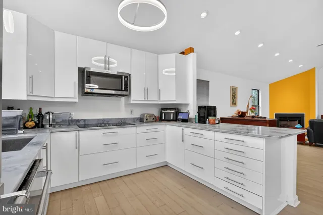 a kitchen with cabinets stainless steel appliances and wooden floor