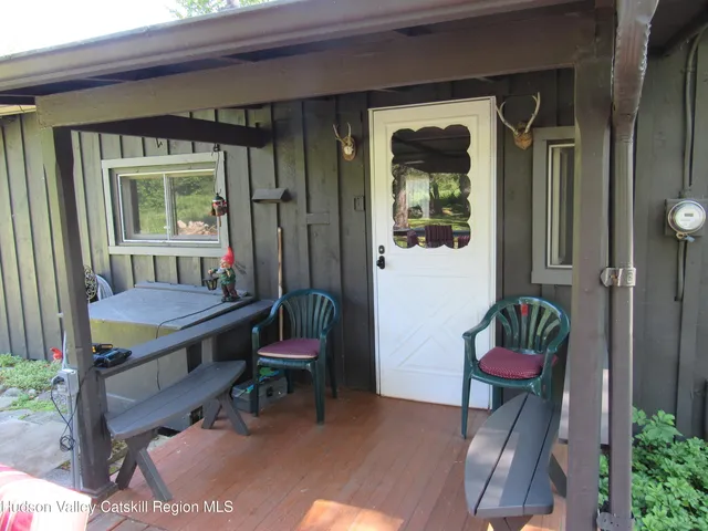 a view of a porch with a table and chairs