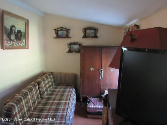 a bedroom with a bed and a lamp on the dresser