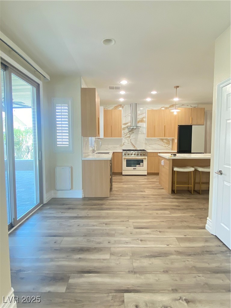 172 Tall Ruff Drive Las Vegas, NV 89148 - Photo 12 of 94 Kitchen featuring light brown cabinets, stove, exhaust hood, light countertops, and recessed lighting