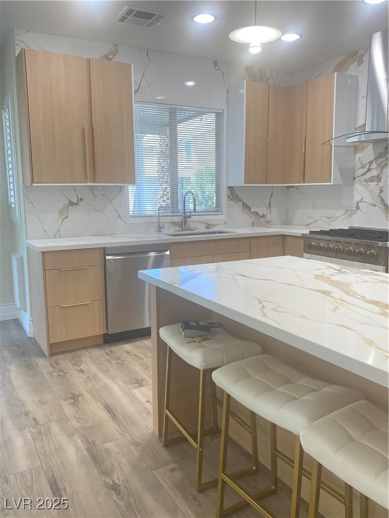 172 Tall Ruff Drive Las Vegas, NV 89148 - Photo 20 of 94 Kitchen featuring dishwashing machine, a sink, ventilation hood, modern cabinets, and a breakfast bar