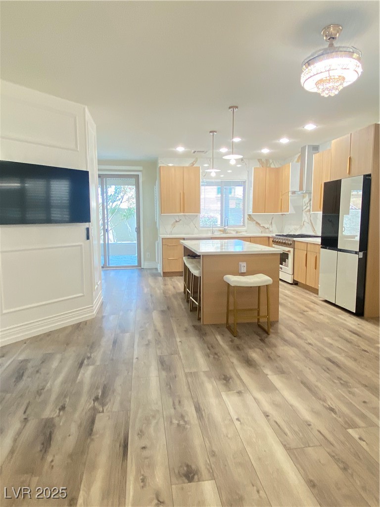 172 Tall Ruff Drive Las Vegas, NV 89148 - Photo 21 of 94 Kitchen featuring
tv, fridge, light brown cabinets, stove, a center island, and recessed lighting