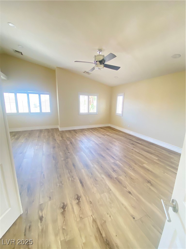 172 Tall Ruff Drive Las Vegas, NV 89148 - Photo 31 of 94 Primary BR double door enty with vaulted ceiling, laminate wood-style flooring, a ceiling fan, and baseboards