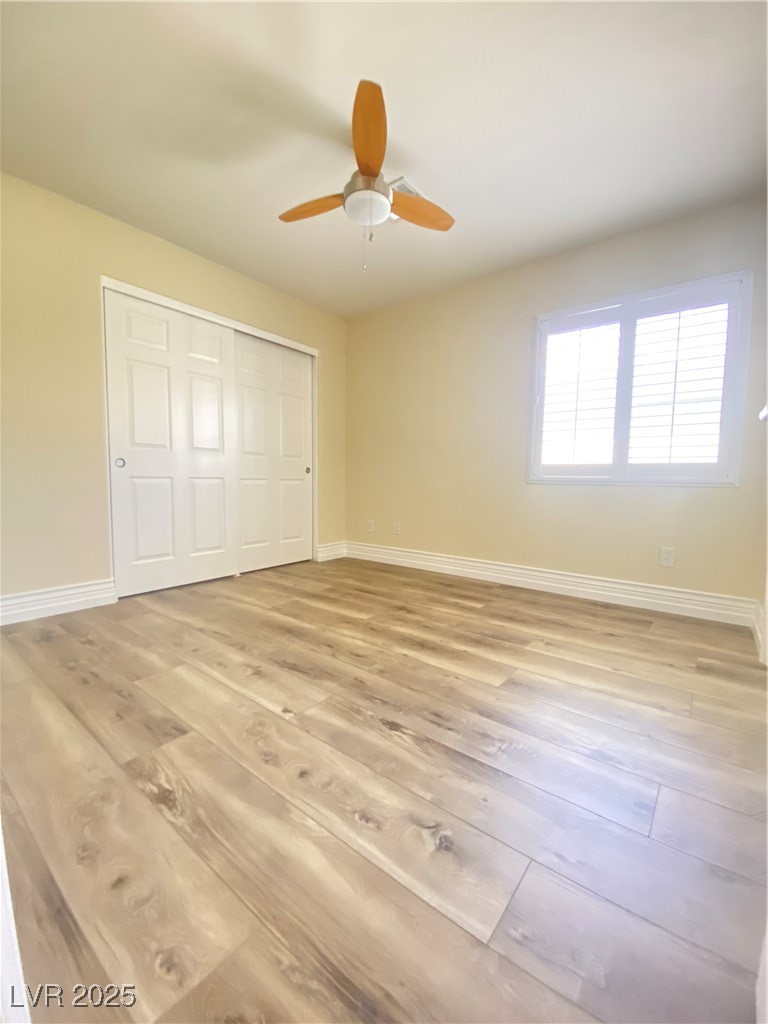 172 Tall Ruff Drive Las Vegas, NV 89148 - Photo 39 of 94 Second bedroom featuring light wood-style floors, baseboards, a closet, and a ceiling fan