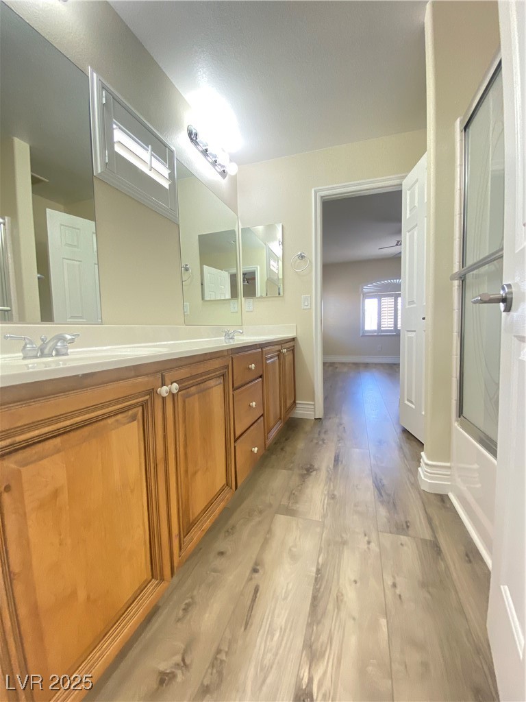 172 Tall Ruff Drive Las Vegas, NV 89148 - Photo 40 of 94 Jack and Jill Full bathroom featuring wood finished floors, double vanity, baseboards, and bath / shower combo with glass door