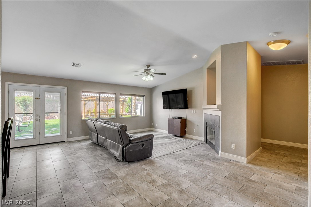 910 Cobblestone Cove Road North Las Vegas, NV 89081 - Photo 4 of 30 Natural light illuminates this spacious living area with ceramic tile floors and a charming fireplace.