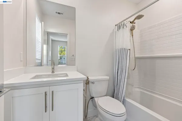 a bathroom with a sink toilet vanity and shower