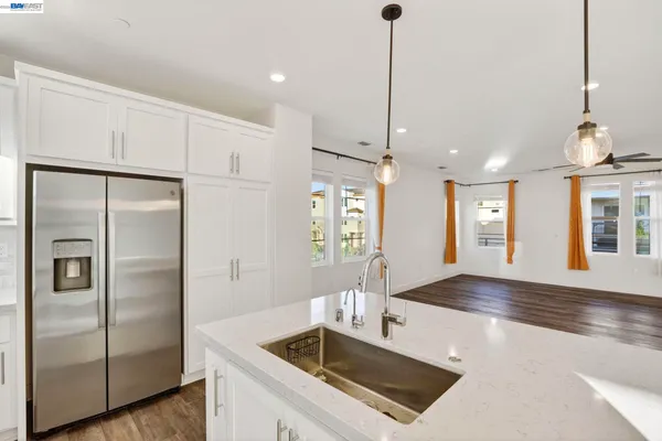 a kitchen with stainless steel appliances granite countertop a refrigerator a sink and a stove