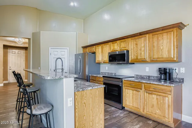 a kitchen with stainless steel appliances granite countertop a stove a sink and a microwave