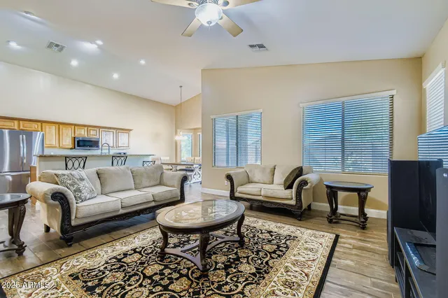 a living room with a table chairs and kitchen view