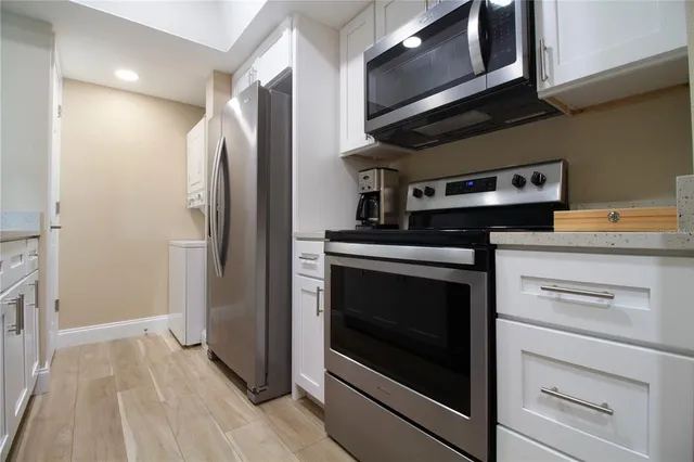 a kitchen with stainless steel appliances granite countertop a stove microwave and refrigerator