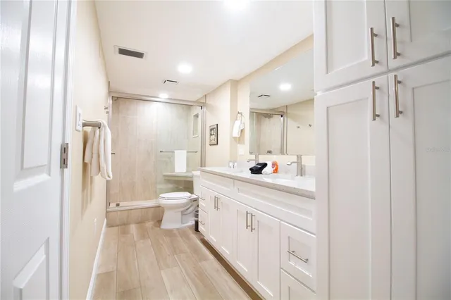 a bathroom with a sink a toilet a mirror and shower