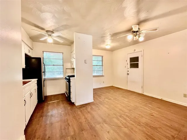 a view of a livingroom with furniture a ceiling fan and wooden floor