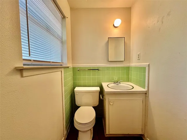 a bathroom with a toilet sink vanity and mirror