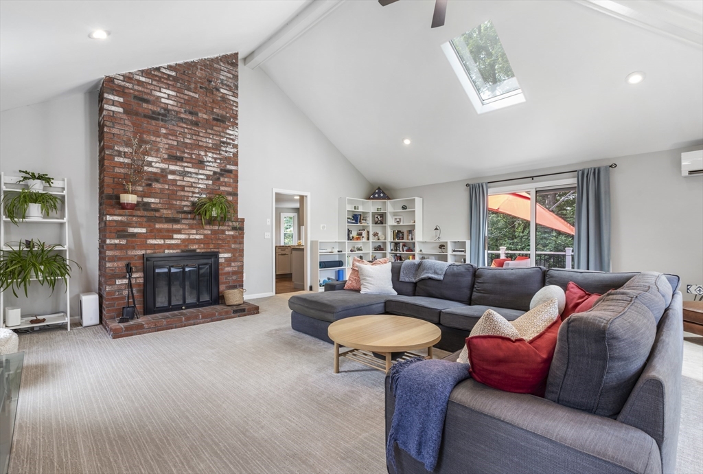 61 Sunset Drive Milford, MA 01757 - Photo 12 of 42 a living room with furniture a fireplace and a floor to ceiling window