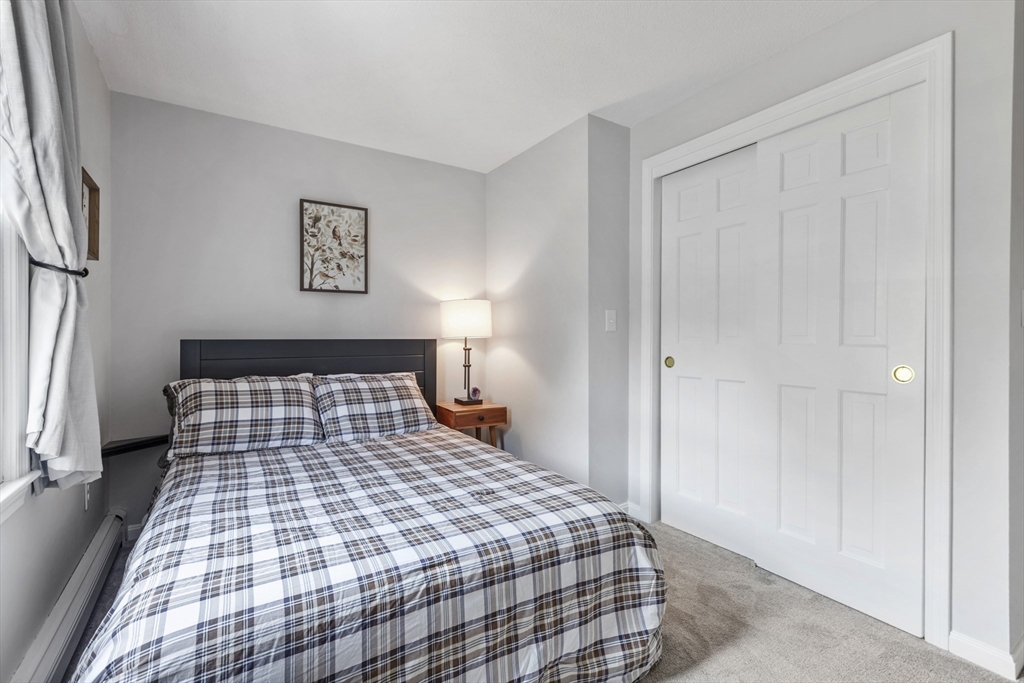 61 Sunset Drive Milford, MA 01757 - Photo 24 of 42 a bedroom with a bed and wooden floor