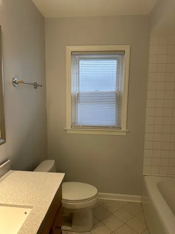 a bathroom with a sink a toilet and a window