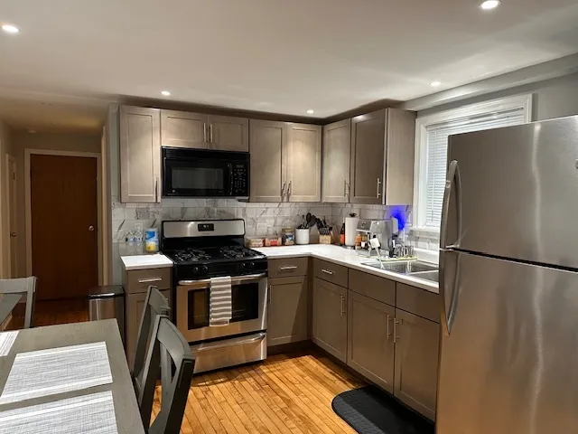 a kitchen with a refrigerator a stove and a sink