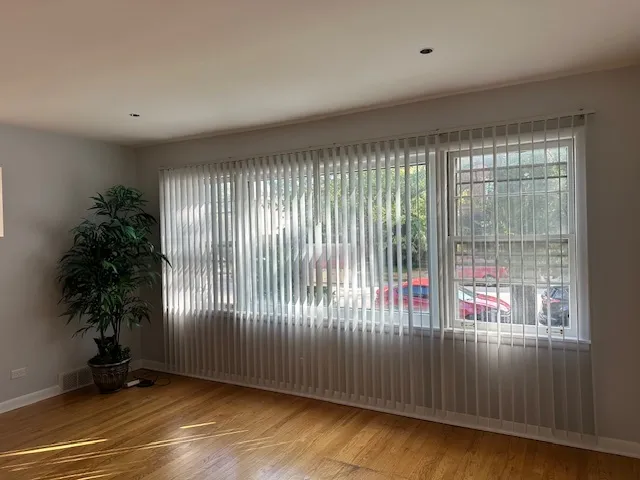 an empty room with floor to ceiling windows and potted plants