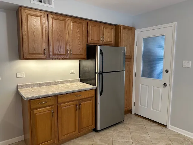 a kitchen with cabinets a refrigerator and a sink