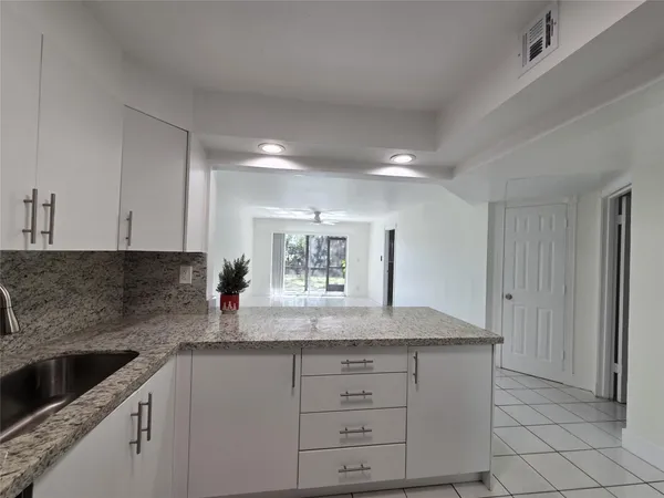 a kitchen with granite countertop a sink and cabinets