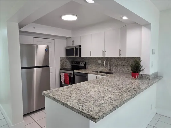 a kitchen with stainless steel appliances granite countertop a refrigerator sink and cabinets
