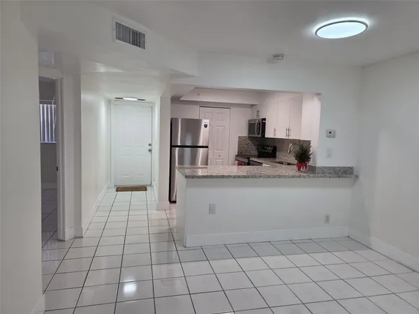 a view of kitchen with granite countertop cabinets