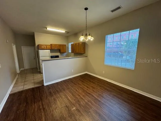 a view of a kitchen with a sink and dishwasher with wooden floor