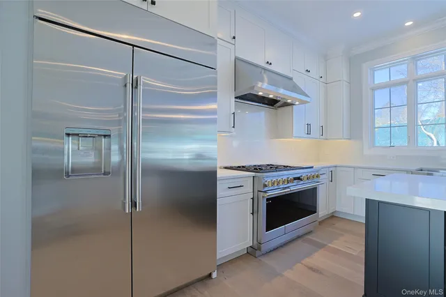 a kitchen with stainless steel appliances granite countertop a refrigerator and a stove