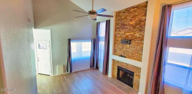 a view of an entryway with wooden floor and a fireplace