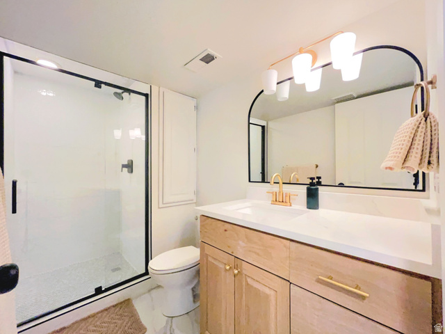 12169 Hidden Valley Road, Unit 44 Sandy, UT 84092 - Photo 32 of 49 Frameless glass shower enclosure with matte black trim, natural wood-finish vanity with gold-tone hardware, arched mirror, contemporary vanity light fixture, and white countertop