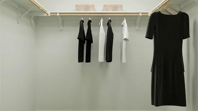 a view of walk in closet with clothes