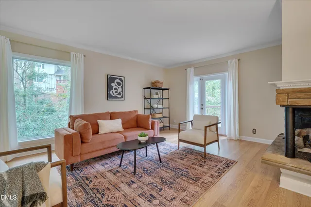 a living room with furniture a rug a lamp and a window